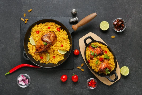 Siyah arka planda malzemelerle geleneksel tavuk biryanisi pişirme ve kızartma tavası.