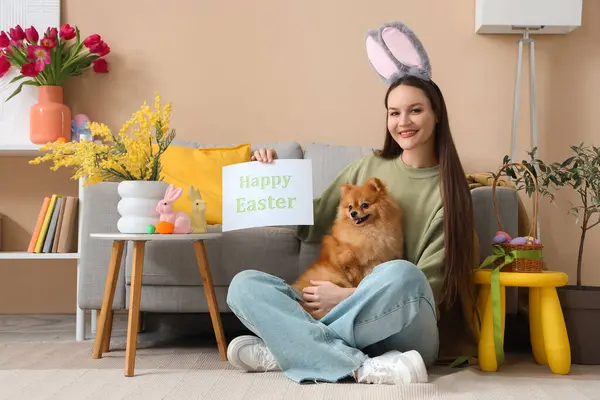 Pomeranya köpeği ve Paskalya için tebrik kartı olan genç bir kadın.