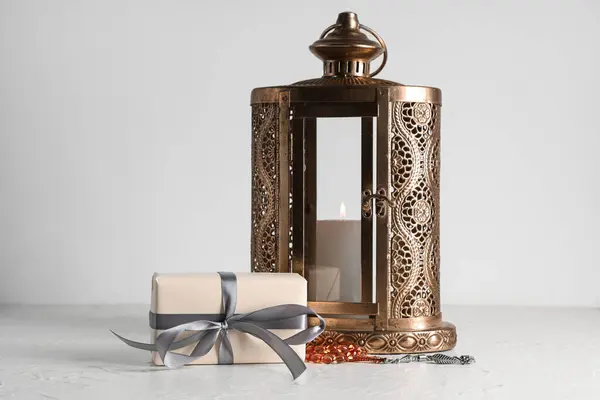 Stock image Gift box with Muslim lamp and prayer beads for Ramadan on white table