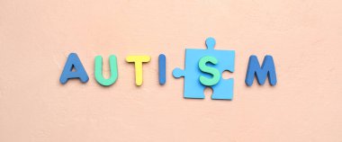 Bej arkaplan parçalı kelime AUTISM