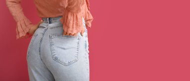 Kırmızı arka planda şık kotlu genç bir kadın. Mesaj için yeri var. Yakın plan.