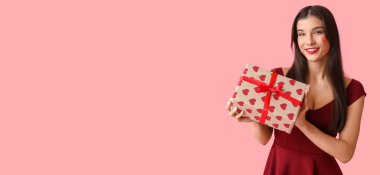 Yüzünde öpücük izleri ve pembe arka planda mesaj için yeri olan güzel bir genç kadın.