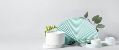 Alçı podyumlar ve yeşil yapraklar gri arkaplanda çiçekler ve metin için boşluk