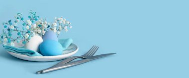 Mavi zemin üzerinde Paskalya yemeği için güzel bir sofra ve metin için yer var.