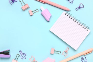 Mavi arkaplanda farklı kırtasiye malzemesi olan defter