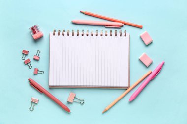 Mavi arkaplanda farklı kırtasiye malzemesi olan defter