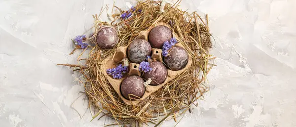 Yuvadaki paskalya yumurtaları hafif grunge arka planı, üst görünüm