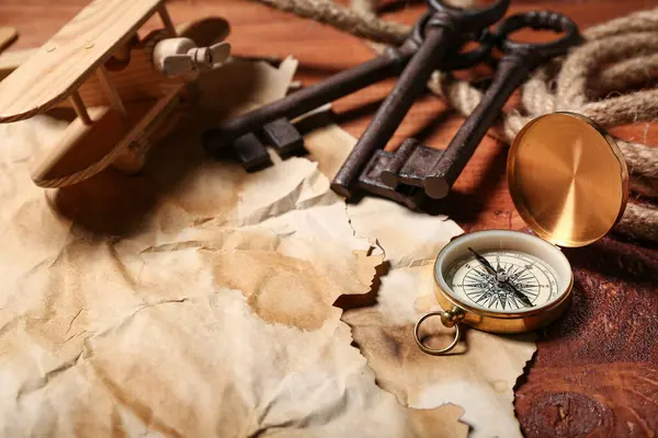 Seyahat ekipmanlı uçak oyuncağı ve kahverengi ahşap arka planda anahtarlar