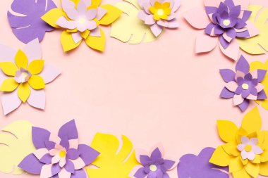 Renkli origami çiçeklerinden yapılmış çerçeve pembe arkaplanda yapraklarla