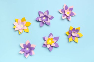 Mavi arkaplanda renkli origami çiçekleri