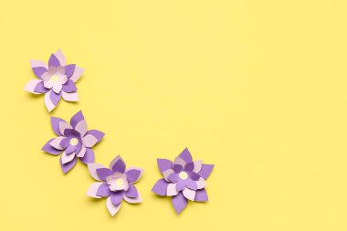 Sarı arkaplanda renkli origami çiçekleri