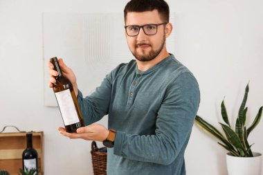 Mutfakta şarap şişesi olan genç bir şarap garsonu.