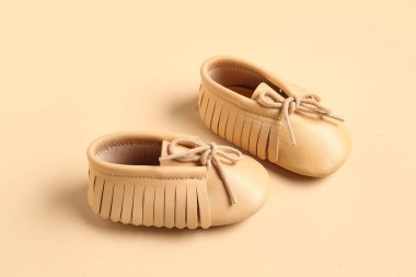 Bej arka planda şık bebek ayakkabıları