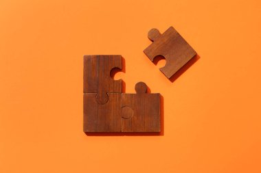 Turuncu arka planda tahta yapboz parçaları