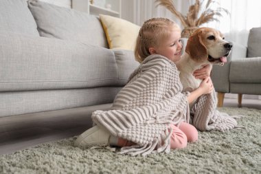 Evinde ekose kumaşlı, kucaklayan küçük sevimli bir kız.