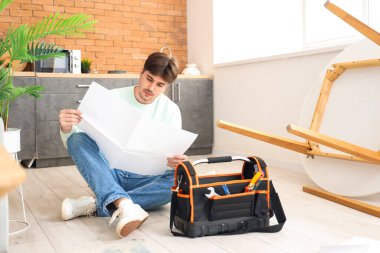 Mutfakta mobilya montajı yapan genç bir adam.