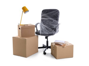 Gergin filme sarılı sandalye, beyaz arka planda lamba ve karton kutular. Ofis taşıma günü konsepti