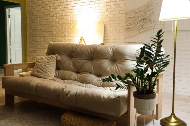 Akşamları beyaz kanepe ve parlayan lambalarla modern oturma odasının içinde.