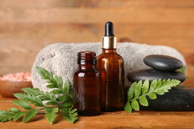 Ahşap zemin üzerinde bitki yaprakları olan spa kompozisyonu