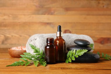 Ahşap zemin üzerinde bitki yaprakları olan spa kompozisyonu