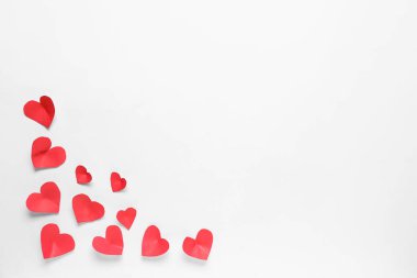 Hafif arka planda küçük kağıt kalpler olan kompozisyon. Sevgililer Günü kutlaması