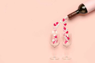 Pembe arka planda Sevgililer Günü için şarap ve gözlüklü kompozisyon