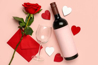 Pembe arka planda Sevgililer Günü için şarap, cam ve gül çiçekli kompozisyon