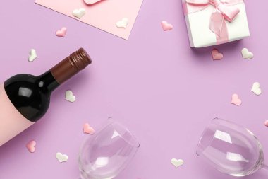 Şarap, bardak, hediye kutusu ve sevgililer günü için eflatun arkaplanlı bir zarf çerçevesi.