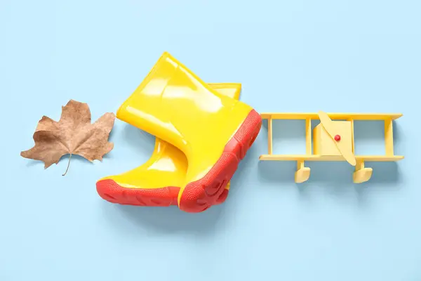 Yellow Gumboots Toy Airplane Autumn Leaf Blue Background — Stock Photo, Image
