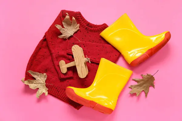 Yellow Gumboots Sweater Toy Airplane Autumn Leaves Pink Background — Stock Photo, Image