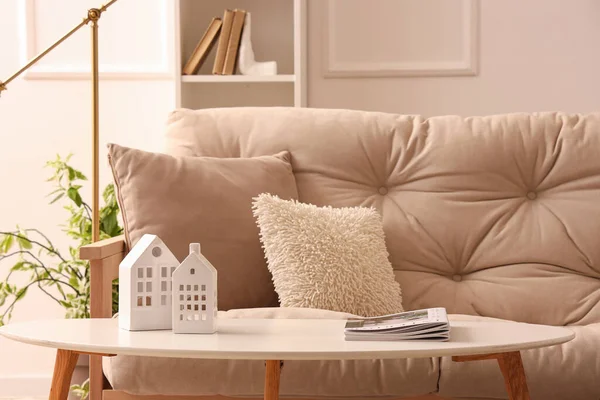 Oturma odasının içinde dergi ve beyaz kanepe olan kahve masası.