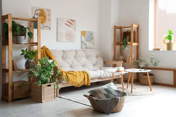 Işıl ışıl oturma odasının içinde rahat beyaz kanepe, sehpa ve bitkiler var.