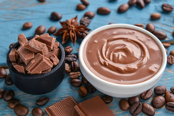 Mavi ahşap arka planda lezzetli eritilmiş çikolatalı kompozisyon