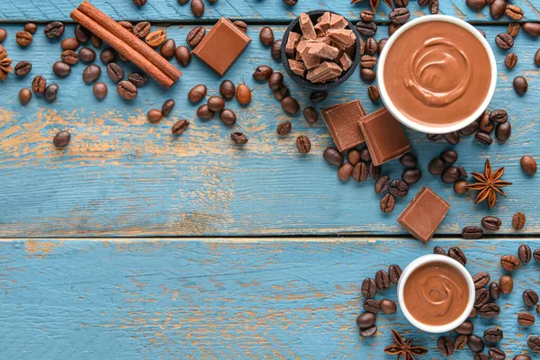 Lezzetli çikolatadan yapılmış çerçeve ve mavi ahşap arka planda kahve çekirdeği.