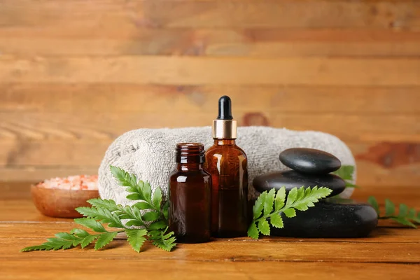 Ahşap zemin üzerinde bitki yaprakları olan spa kompozisyonu