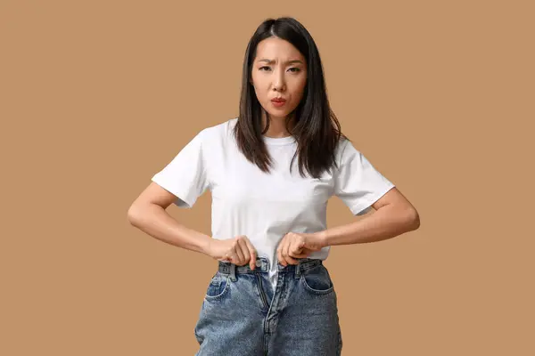 Belle Jeune Femme Asiatique Mécontente Boutonner Jeans Élégants Sur Fond — Photo