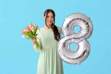 Şekil 8 şeklinde gümüş hava balonu ve mavi arka planda güzel laleler olan güzel Asyalı bir kadın. Uluslararası Kadınlar Günü