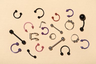 Renk arkaplanındaki piercing için şık mücevherlere sahip kompozisyon