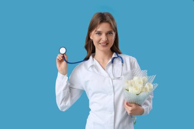 Steteskoplu kadın doktor ve mavi arka planda beyaz laleler. Uluslararası Kadınlar Günü kutlamaları