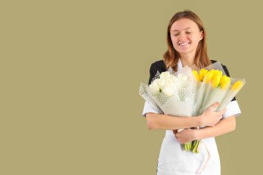 Yeşil arka planda lale buketleri olan genç oda hizmetçisi. Uluslararası Kadınlar Günü kutlamaları