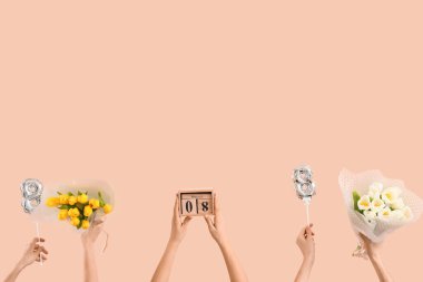 8 numaralı figür şeklinde balonları olan kadın eller, bej arka planda lale demetleri ve takvimi. Uluslararası Kadınlar Günü kutlamaları