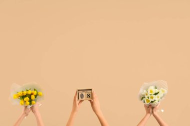 Lale buketleri ve bej arka planda takvimi olan kadın elleri. Uluslararası Kadınlar Günü kutlamaları