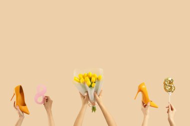 Bir buket lale, yüksek topuklu ayakkabılar ve bej arka planda 8 figürlü kadın eli. Uluslararası Kadınlar Günü kutlamaları