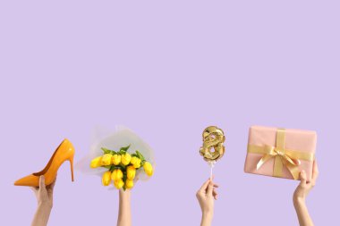Lale buketi, hediye kutusu ve leylak arka planda yüksek topuklu ayakkabı olan kadın elleri. Uluslararası Kadınlar Günü kutlamaları