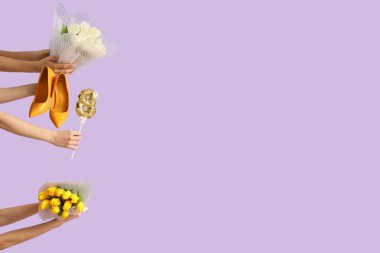 Lale buketli kadın eller, figür 8 şeklinde balon ve leylak arka planda yüksek topuklu ayakkabılar. Uluslararası Kadınlar Günü kutlamaları