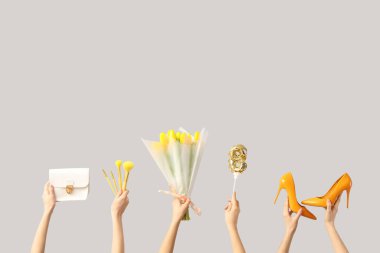 Lale buketli kadın elleri, yüksek topuklu ayakkabılar ve beyaz arka planda el çantası. Uluslararası Kadınlar Günü kutlamaları