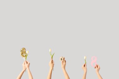 8 figürlü kadın eller ve beyaz arka planda laleler. Uluslararası Kadınlar Günü kutlamaları