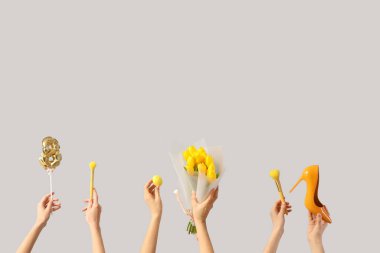 Lale buketli kadın elleri, yüksek topuklu ayakkabılar ve beyaz arka planda makyaj fırçaları. Uluslararası Kadınlar Günü kutlamaları