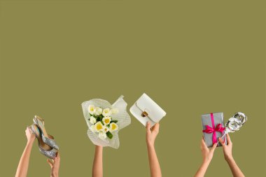 Lale buketi, hediye kutusu ve yeşil arka planda yüksek topuklu ayakkabıları olan kadın elleri. Uluslararası Kadınlar Günü kutlamaları