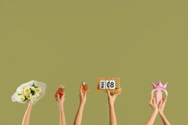 Yeşil arka planda bir buket lale, parfüm ve takvime sahip kadın elleri. Uluslararası Kadınlar Günü kutlamaları